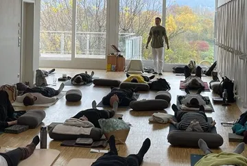 People lying on mats in a yoga studio.