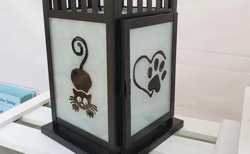 Black lantern with cat and paw designs.