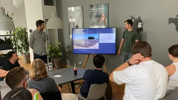 Gruppe beobachtet zwei Sprecher im Büro.
