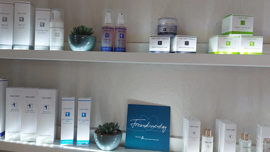 Skincare products on white shelves with decoration.