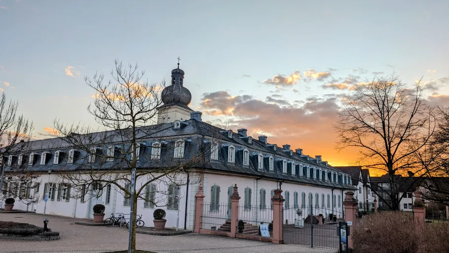 Historic building with tower at sunset.