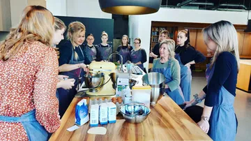 Group gathered around kitchen preparing food.