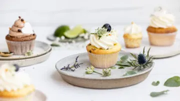 Cupcakes mit Zuckerguss auf dekorativen Tellern.