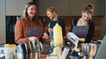 Drei Frauen backen zusammen in einer Küche.