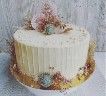 Dekorierte Torte mit getrockneten Blumen und Laub.