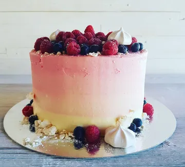 Ombre-Kuchen mit Beeren auf Holztisch.