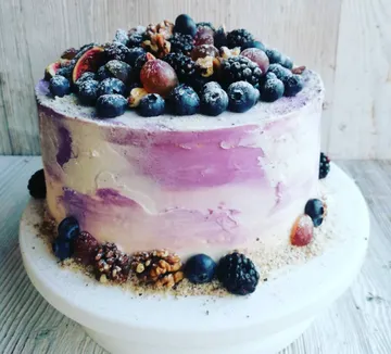 Cake with fruits and nuts on stand.