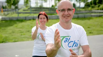 Two people practicing Tai Chi outdoors.