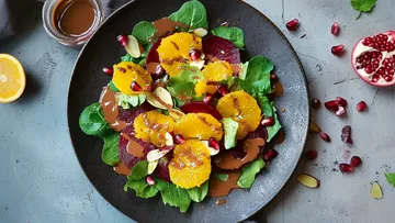 Salad with orange, beets, spinach on a plate.