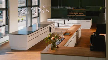 Moderne Küche mit großen Fenstern, Holzboden.