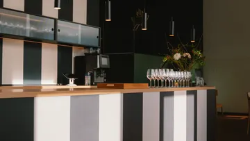 Moderne Bar mit Streifenmuster und Weingläsern.