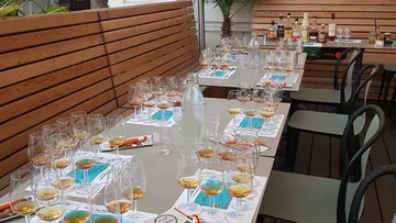 Whiskeygläser auf gedeckten Tischen draußen.