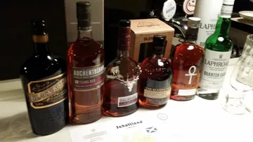 Sechs verschiedene Whiskyflaschen auf einem Tisch.