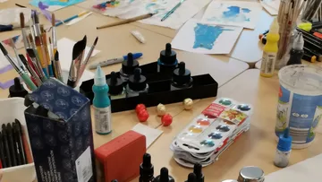 Künstlerbedarf auf einem Tisch verstreut.