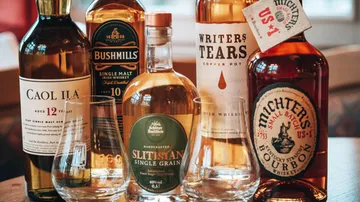 Verschiedene Whiskeyflaschen auf einem Holztisch.