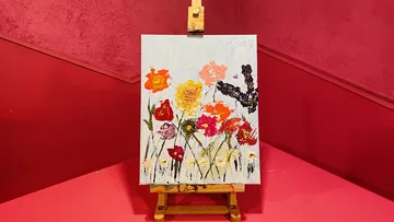 Colorful flower painting on easel in a room.