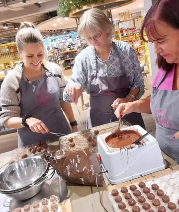 Drei Frauen machen Pralinen drinnen.
