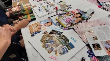 People creating collages with magazines on a table.