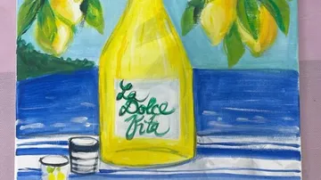Yellow bottle on table with lemons and sea.