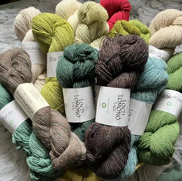Skeins of yarn in various colors on a surface.