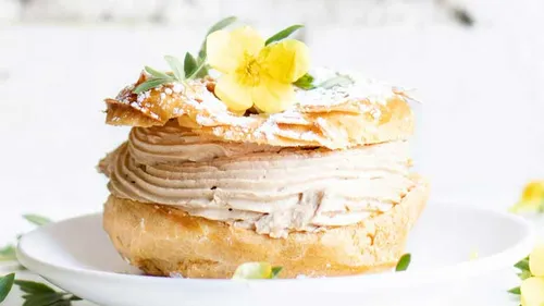 Gebäck mit Creme und gelber Blumendekoration.