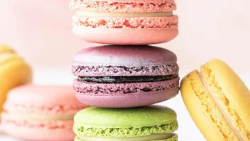 Bunte Macarons auf Tisch gestapelt.