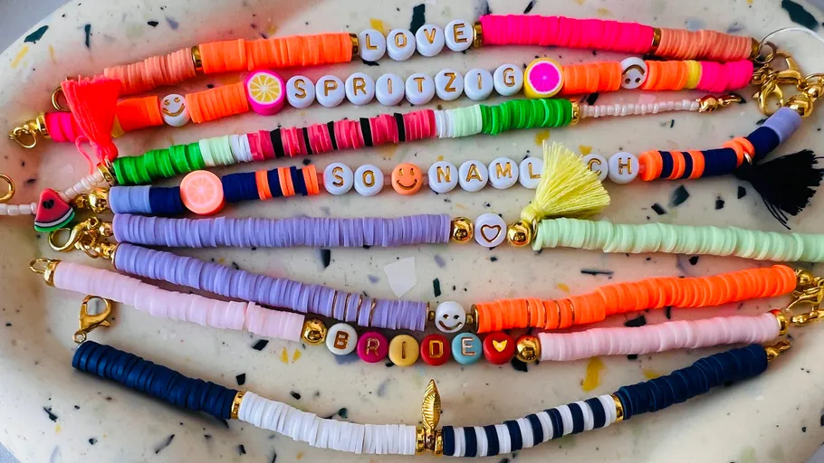 Colorful bracelets with bead texts on table.