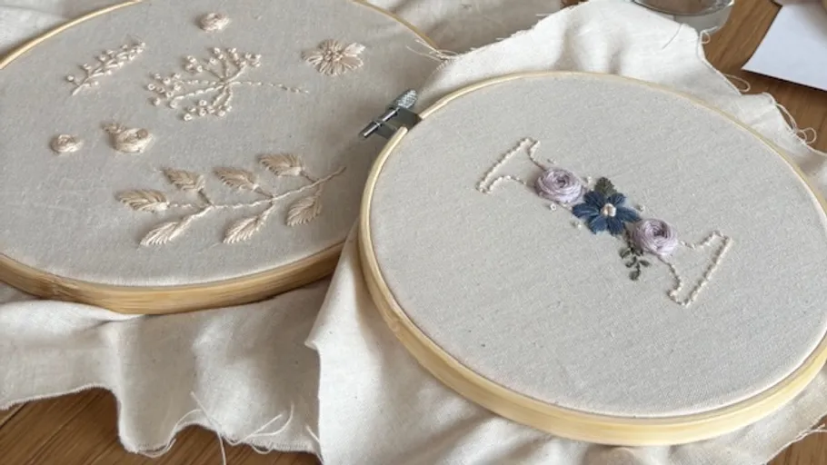Two embroidery hoops with floral designs.