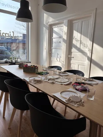 Workshop-Tisch mit Bastelarbeiten und Stühlen.