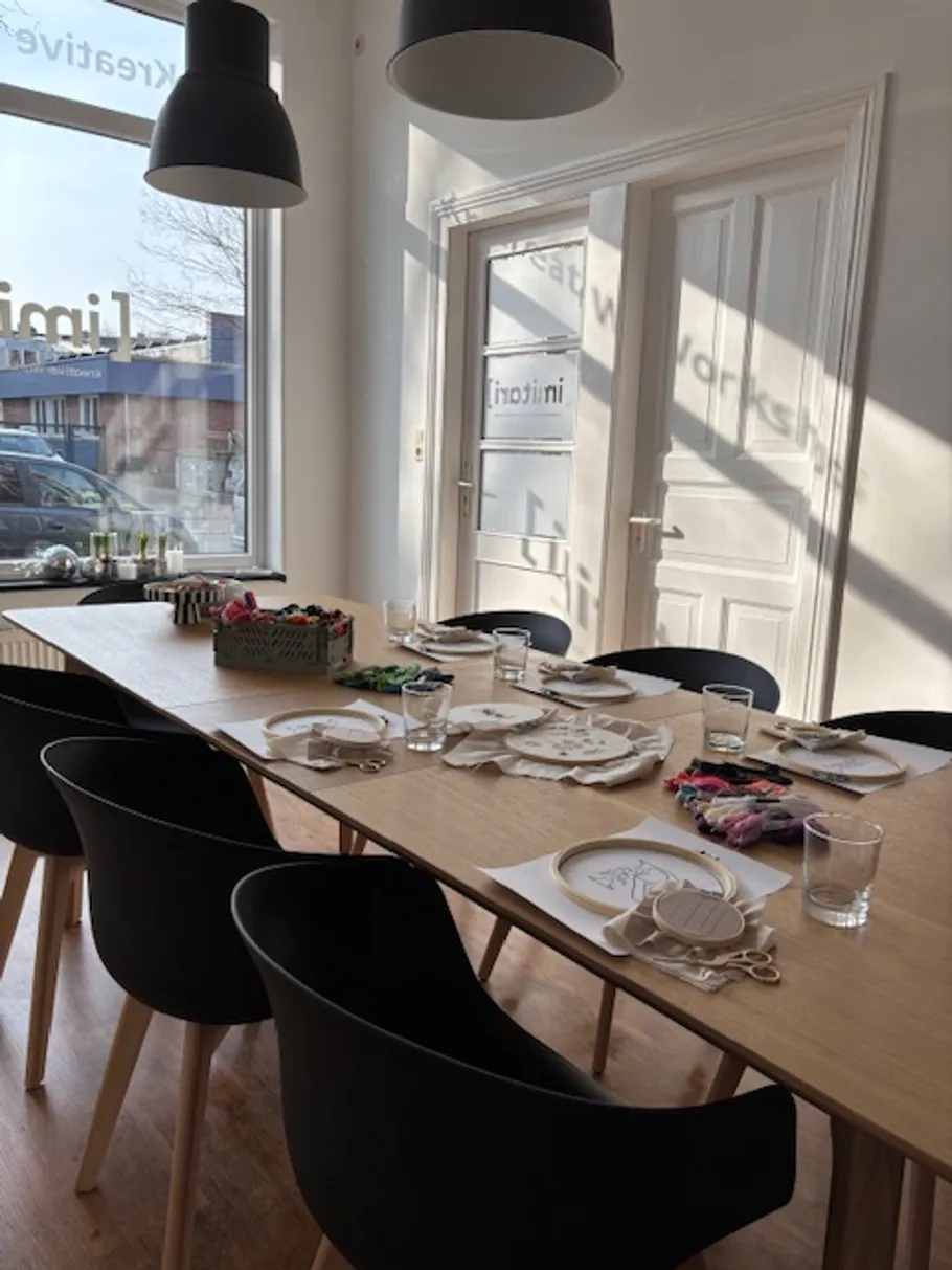 Workshop-Tisch mit Bastelarbeiten und Stühlen.