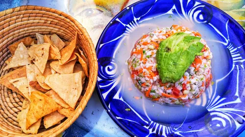 Ceviche on plate with chips in basket.