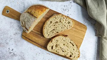 Geschnittenes Sauerteigbrot auf Holzbrett.