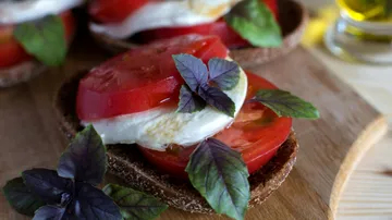 Caprese-Sandwich mit Tomaten und Basilikum auf Brot.