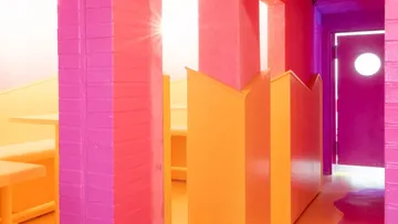 Lebendiger pink-orange Flur mit Sitznischen.
