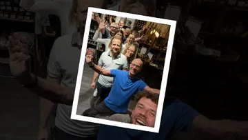 Gruppe lächelt und winkt in einem Laden.