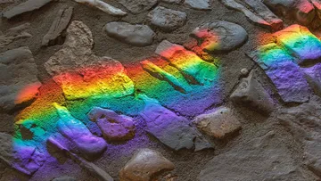 Regenbogenlichtmuster auf Steinwand.