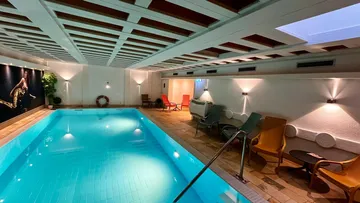 Innenpool mit Liegestühlen, moderne Beleuchtung.