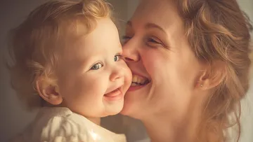Mutter und Baby lächeln im warmen Licht.
