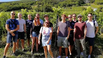 Gruppe von Personen in einem Weinberg.