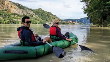 Two people kayaking on a river.