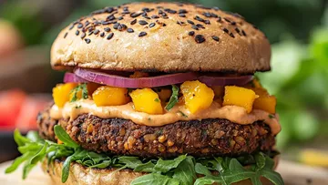 Veggie burger with mango salsa and arugula.