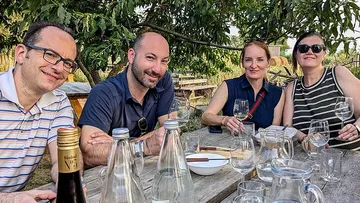 Four people sitting at an outdoor table.