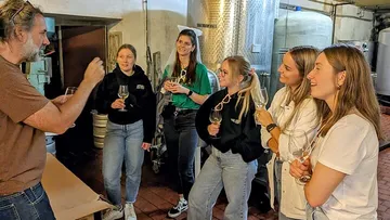 Gruppe probiert Wein im Keller.