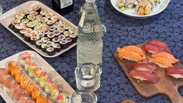 Assorted sushi on a table with drinks.