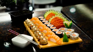 Assorted sushi on a wooden tray.