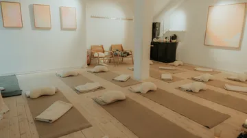Leeres Yoga-Studio mit Matten und Kissen.