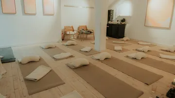 Yogastudio mit Matten, Kissen und Decken.