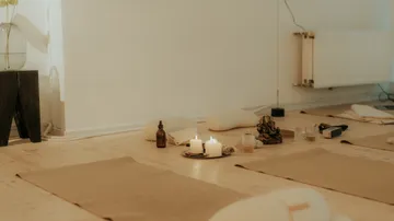 Yogamatten mit Kerzen in einem ruhigen Raum.