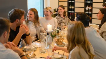People socializing around dining table indoors.