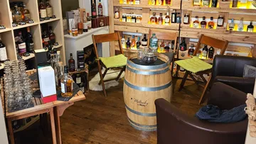 Whisky-Verkostungsraum mit Fass-Tisch und Flaschen.